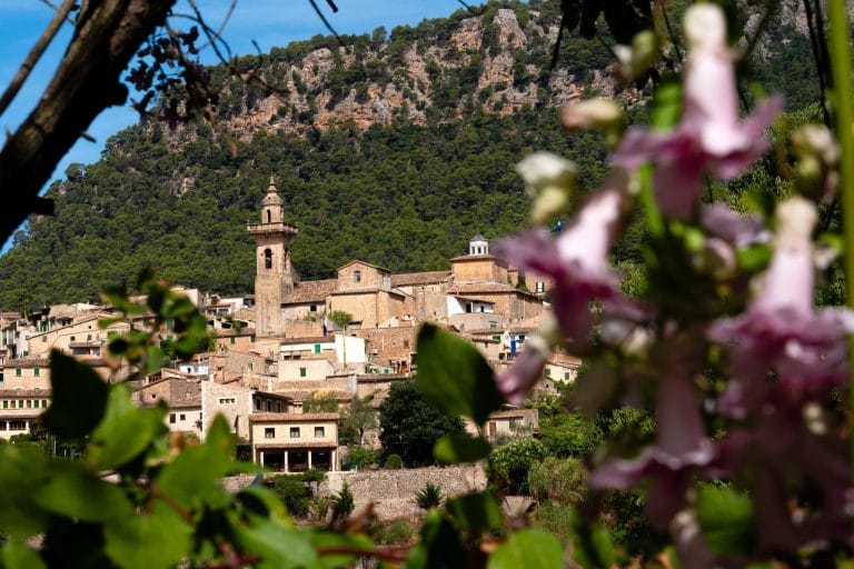 Vista de la ciudad de Valldemossa en la isla de Mallorca, España, rodeada de montañas y naturaleza.