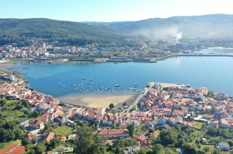 Vista aérea de Corcubión con el casco urbano, el puerto y la playa en la ría de Corcubión, Galicia