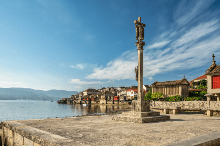 Vista icónica del pintoresco pueblo marinero de Combarro, Pontevedra, Galicia, con su famoso cruceiro y los hórreos tradicionales a orillas de la ría.