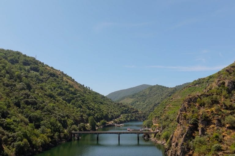 Puente sobre el río Sil en el entorno del Monasterio de Santo Estevo, rodeado de vegetación y montañas en la Ribeira Sacra.