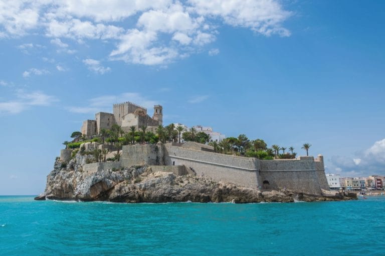 Castillo del Papa Luna en Peñíscola visto desde el mar con aguas turquesas y cielo despejado