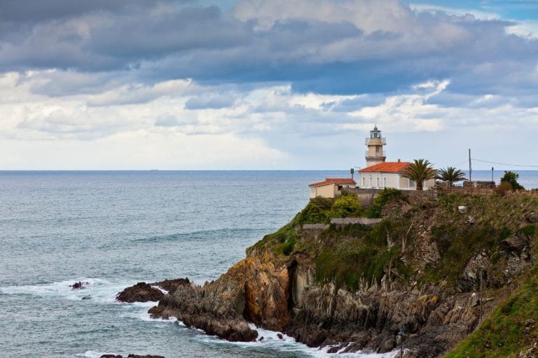 Faro de Cudillero en lo alto de un acantilado sobre el mar Cantábrico, en la costa de Asturias