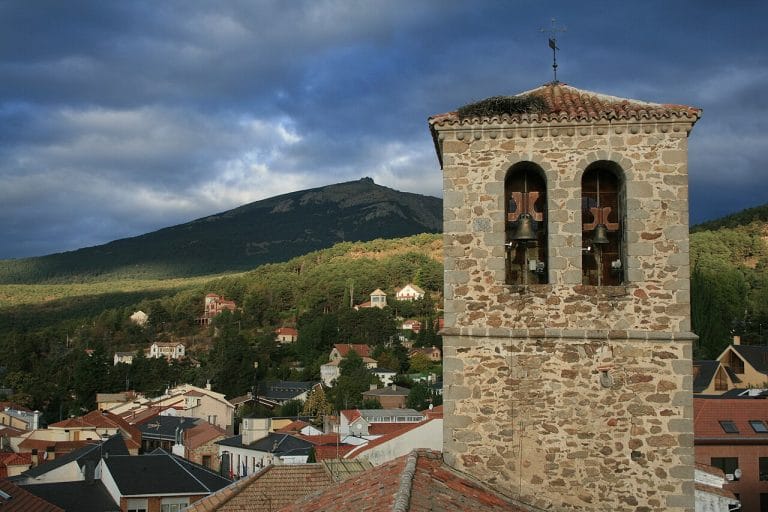 Vista de la iglesia de Miraflores de la Sierra con la montaña de La Najarra al fondo en la Sierra de Guadarrama, Madrid