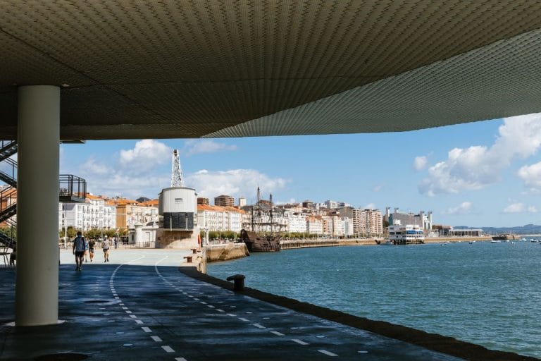 Vista del paseo marítimo junto al Centro Botín en Santander con el puerto y edificios de la ciudad al fondo