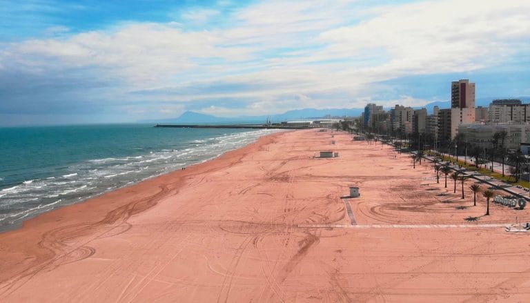 Vista panorámica de la playa de Gandía con arena fina, paseo marítimo y edificios al fondo en la costa valenciana