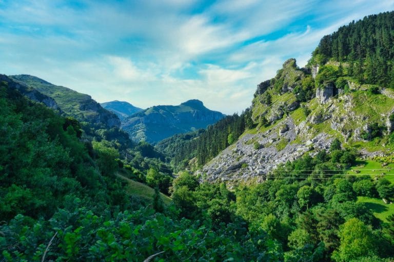 Paisaje natural de los Valles Pasiegos con montañas, bosques y cielo azul en Cantabria